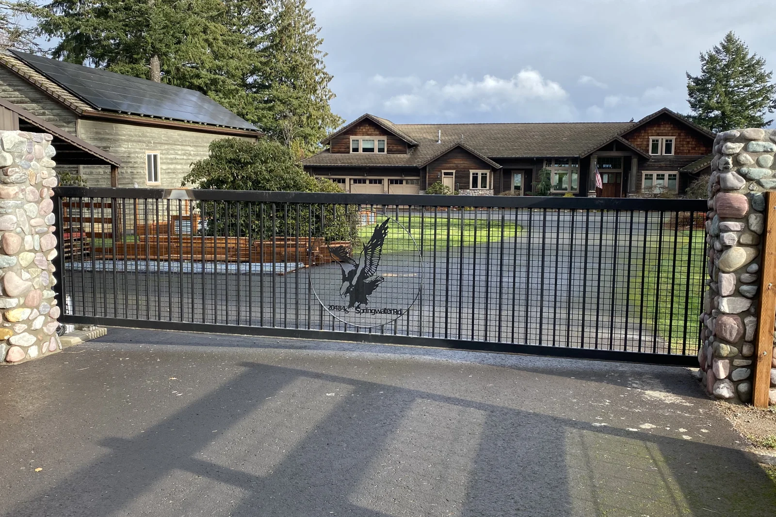 Black metal sliding gate with plasma-cut eagle logo
