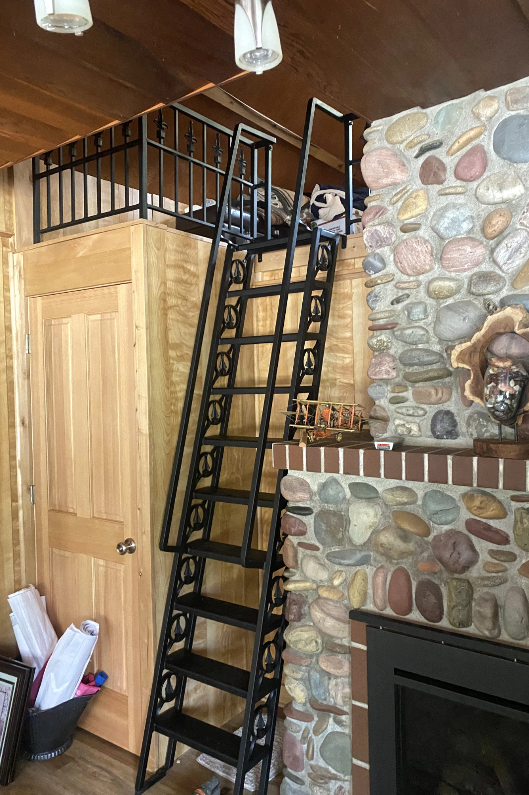 A premium custom black steel loft ladder with ornamental ironwork scroll accents and sleek handrails. | Chip and Dale's Iron Works